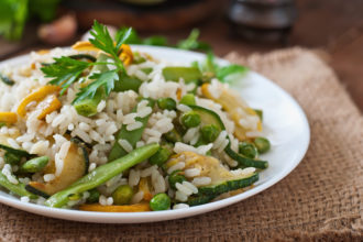 Assiette de riz avec des petits pois et de la courgette